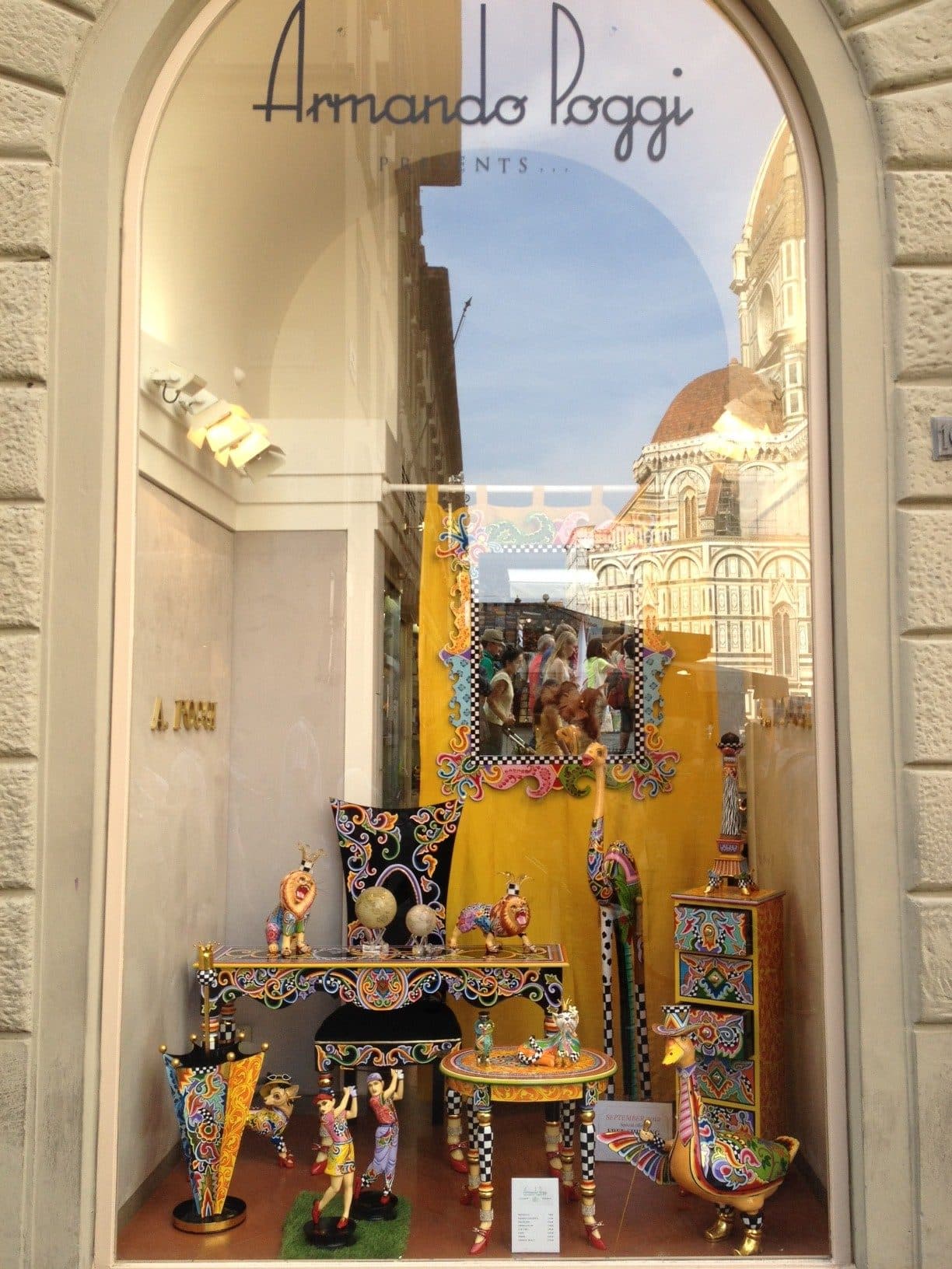 El escaparate de Armando Poggi en Florencia, con muebles y figuras de Tom's Drag y el Duomo reflejado en el cristal