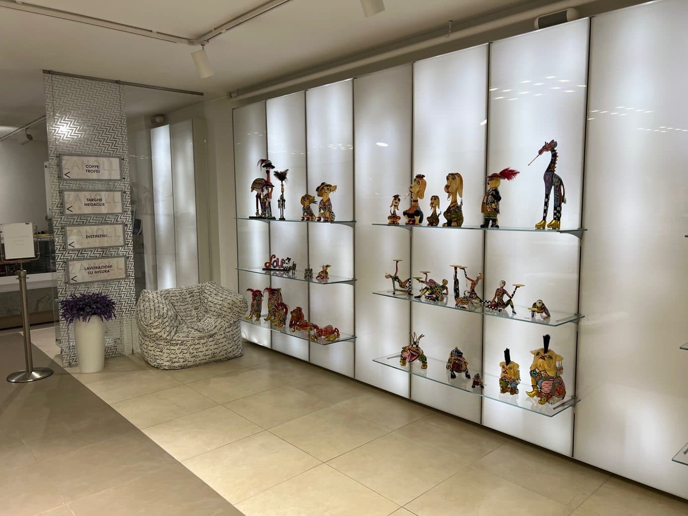 Figuras de Tom's Drag en estantes de cristal iluminados en el showroom de Zanolli en Brescia